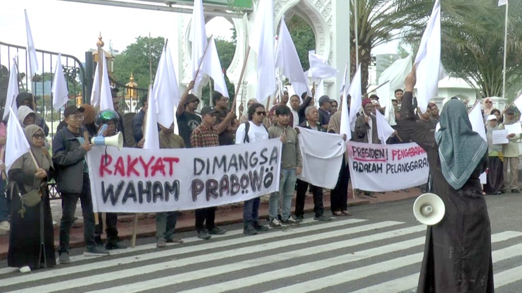 Massa yang tergabung dalam Koalisi Masyarakat Sipil Aceh Peduli Bencana Sumatera menggelar aksi demonstrasi di depan Masjid Raya Baiturrahman, Banda Aceh, Kamis (18/12/2025). (FOTO: Taufik Kelana I Habadaily.com)